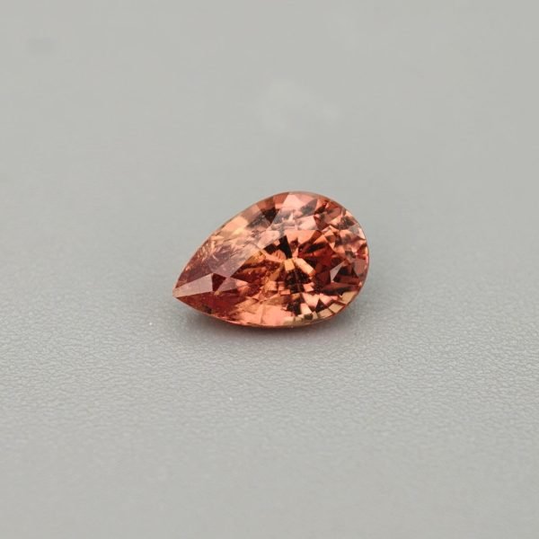 Zaffiro padparadscha goccia 1.04 ct su sfondo grigio